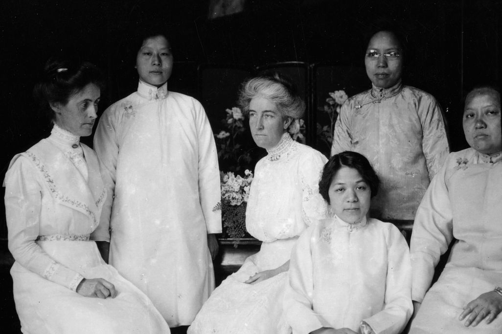 Tien Fuh Wu (standing in the back, on the left) and Donaldina Cameron (seated, center) with a group of women who may have been Mission Home staffers. _ Courtesy of Louis B. Stellman, California State Library..png