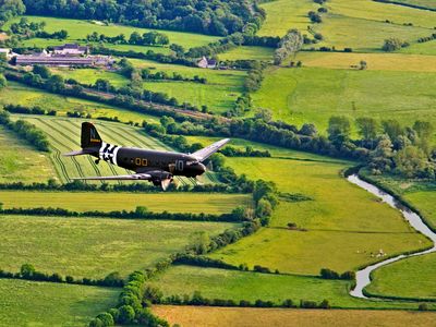 Over the now-peaceful farms of Sainte-Marie-du-Mont, which 75 years ago was within Drop Zone C for D-Day paratroopers, a C-47 returns to base after delivering its paratroop reenactors. They were there for the 2014 commemoration of one of the most momentous days of World War II.