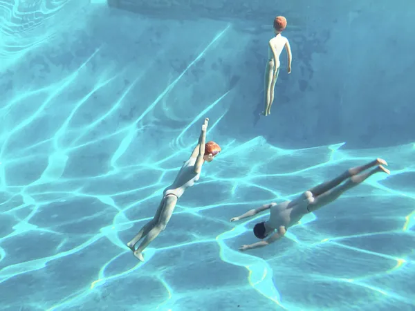 Dolls Posed as Swimmers Gliding Through a Pool’s Blue Depths thumbnail