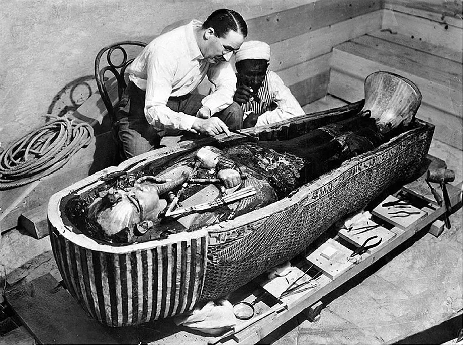 Howard Carter (left) and an unidentified Egyptian worker examine Tut's sarcophagus