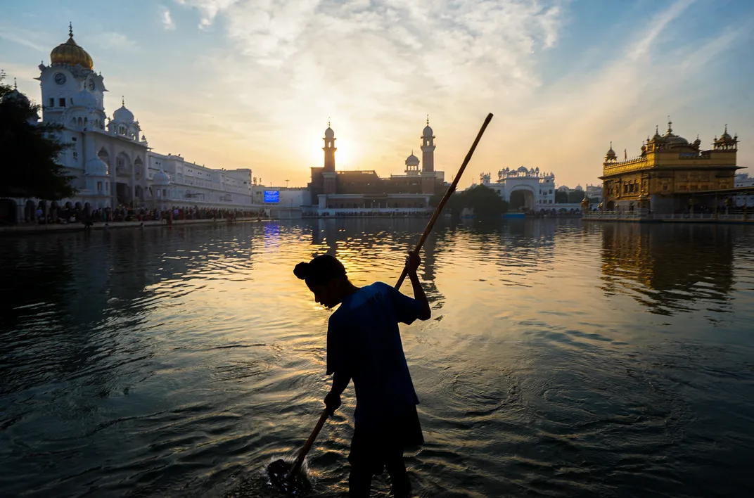 A boy cleans the sacred pool