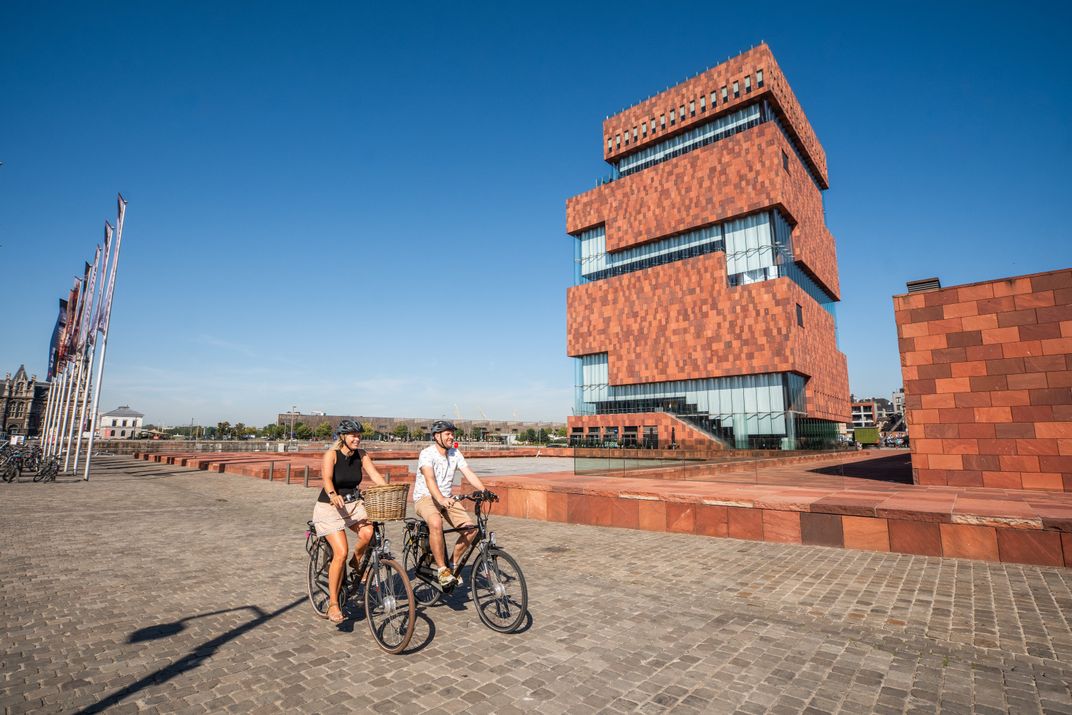 Cycling past the modern architecture of the MAS Museum in Antwerp. Credit: VisitFlanders, MAS