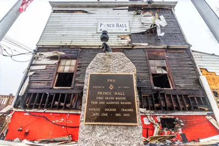 A dedication marker outside of the damaged Prince Hall Masonic Lodge.