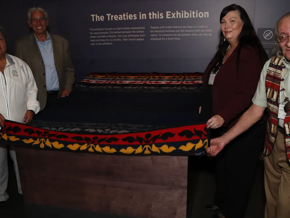 Leaders of Delaware tribes holding the edges of a blanket covering the Treaty of Fort Pitt.