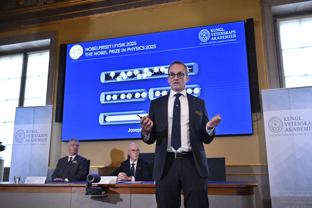 Nobel Committee member Goeran Johansson stands in front of a quantum mechanics diagram during the 2025 Nobel Prize in Physics announcement.