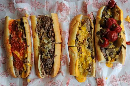 Pat's King of Steaks cheesesteaks (left to right): pizza cheesesteak, steak with provolone and onions, steak with cheez whiz and onions and the steak with mushrooms, onions and cheez whiz topped with hot peppers.