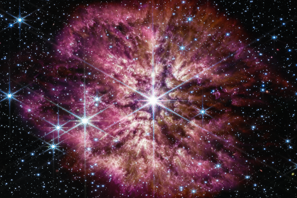 Purple and pink nebular surrounding bright white star against dark background