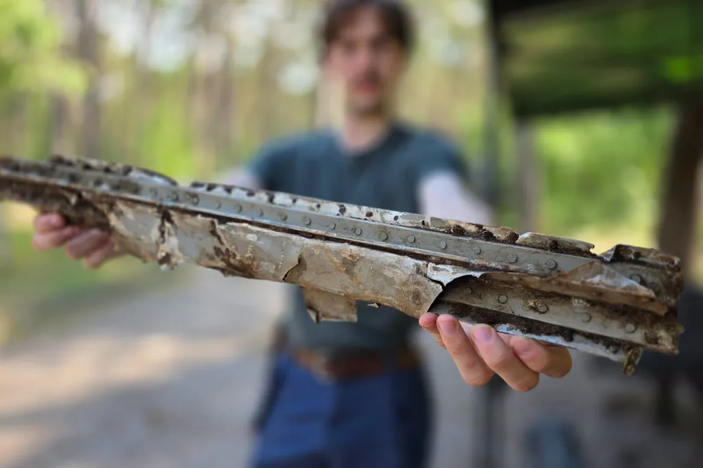 A blurry photo of a man holding up a piece of debris