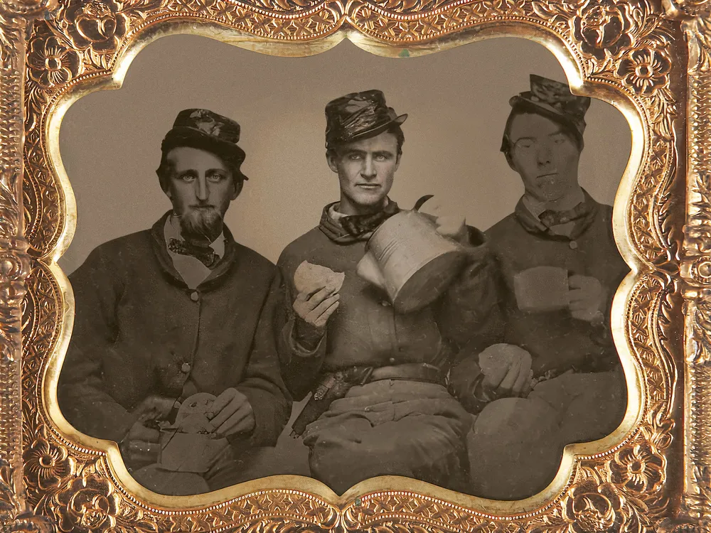 Union soldiers sit will coffee and bread in a portrait