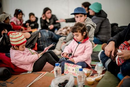 Young Syrian refugees play with donated paper and pens in the former Oxy transit camp in Lesvos, Greece.