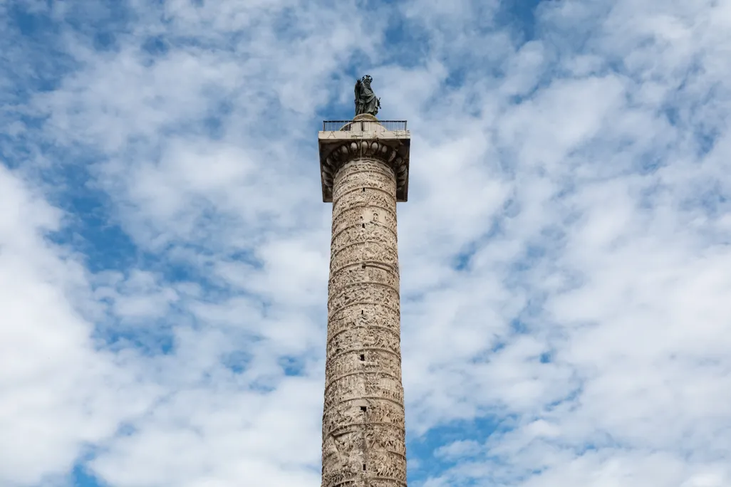 A column with imagery against a cloudy sky