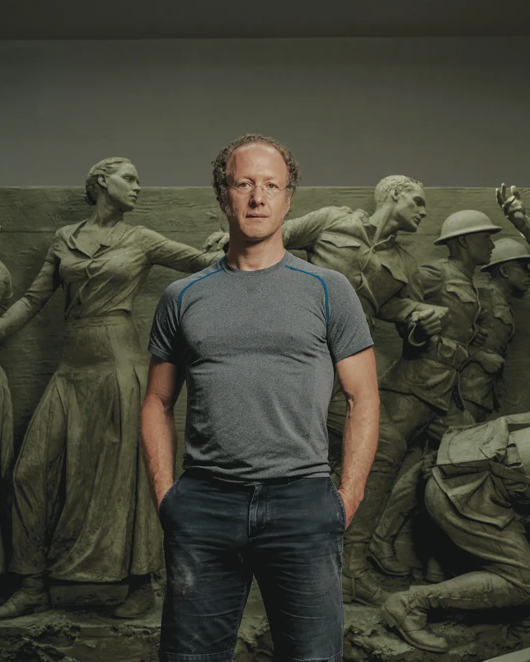 a man in front of large scale scultpures