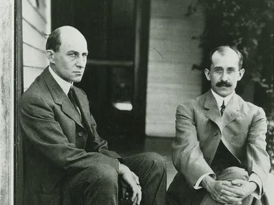 Orville Wright (seated at right, with Wilbur) wears what’s known as “the Chevron,” a thick mustache that covers the top of the upper lip. 
“He had sported a reddish mustache since high school,” writes Tom Crouch in his 2003 book The Bishop’s Boys. “Once full, almost a handlebar, it was now clipped short, just bushy enough to cover a pair of very thin lips that turned up at one corner when he smiled. He was the enthusiast of the pair, ever on fire with new inventions, and the optimist as well, the one who always saw the brighter side.”
There was a (small) outcry when Orville didn't make The Art of Manliness’ list of “35 Manliest Mustaches of All Time.” The father of aviation lost out to a puppet—the Swedish Chef from "the Muppet Show"—and a cartoon character, Yosemite Sam.