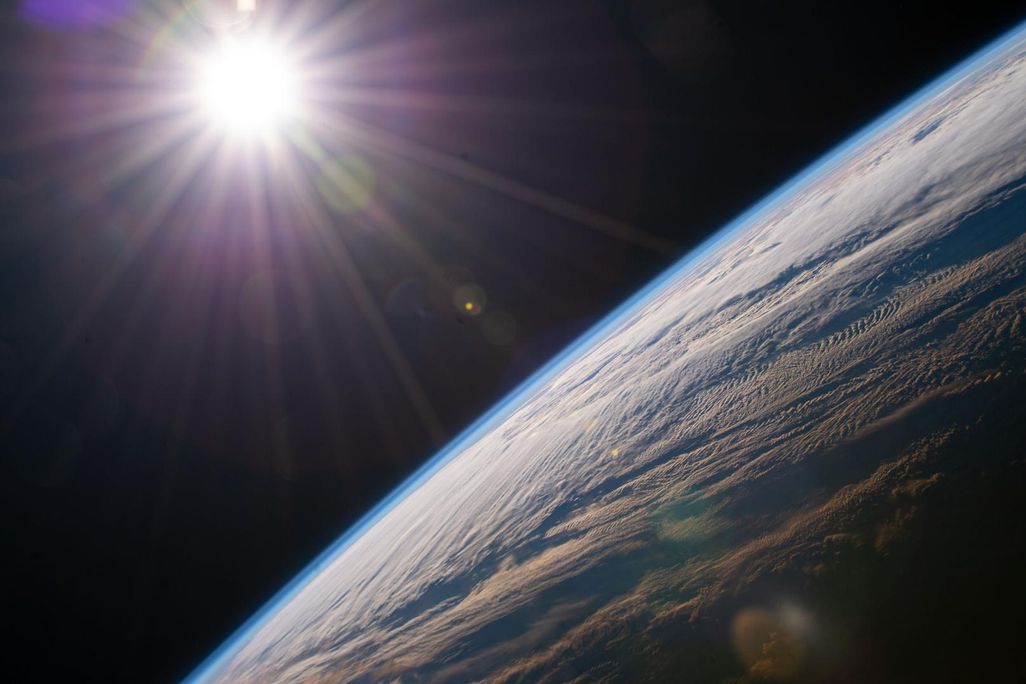 Sun shining light onto Earth as seen from space