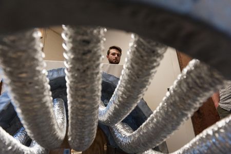 University of Vermont engineering student Joseph Maser gazes down at the prototype of the inflatable airlock for space stations and vehicles that he and three other students built.