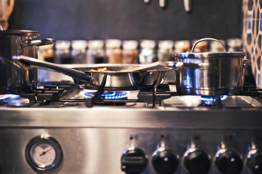 A gas stove with pots and pans on top of it