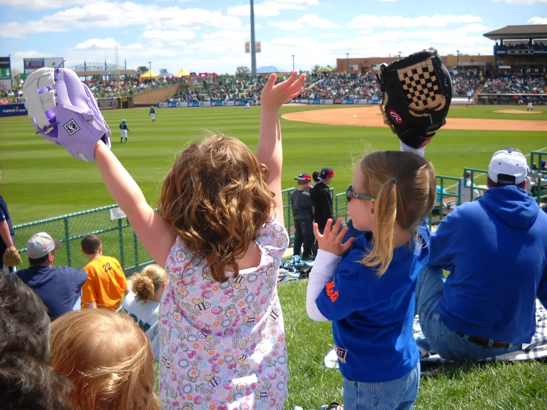 fans with baseball gloves anticipate catching a foul ball