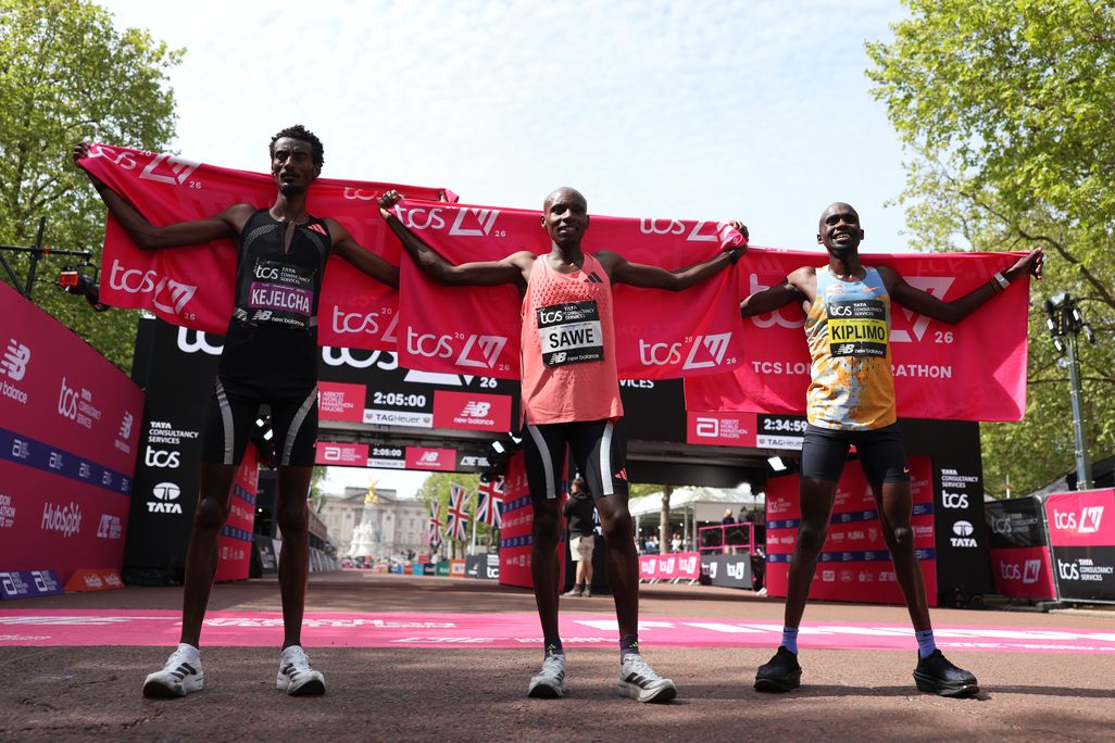 three marathon racers holding banners