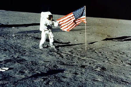 Charles "Pete" Conrad Jr. stands with the U.S. flag on the lunar surface during the Apollo 12 mission.