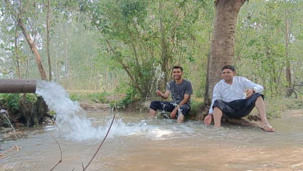 Two friends in the lap of natural vegetation and artificially extraction of ground water thumbnail