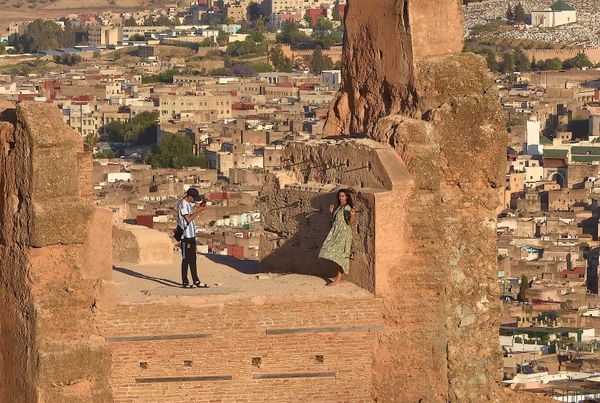 Teenagers taking photos at sunset on the historic walls of Fez, Morocco thumbnail