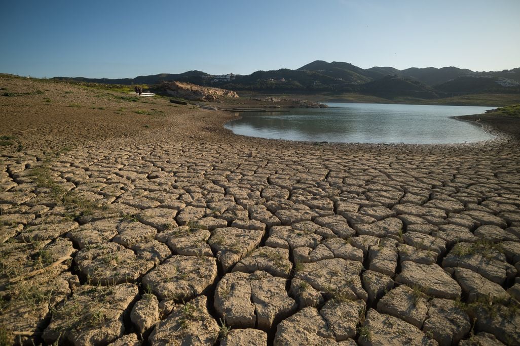 dry, cracked ground on the shores of a heavily receded reservoir in eastern Spain.