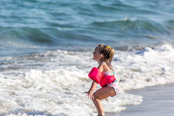 A little girl welcomes the ocean. thumbnail