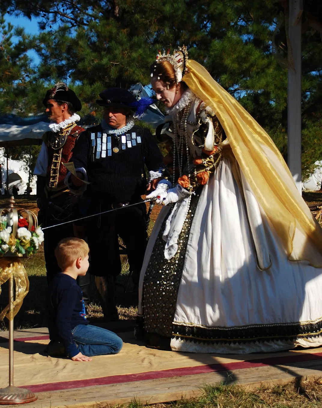 A performer dressed as Elizabeth I knights a visitor at the 2008 Louisiana Renaissance Festival.