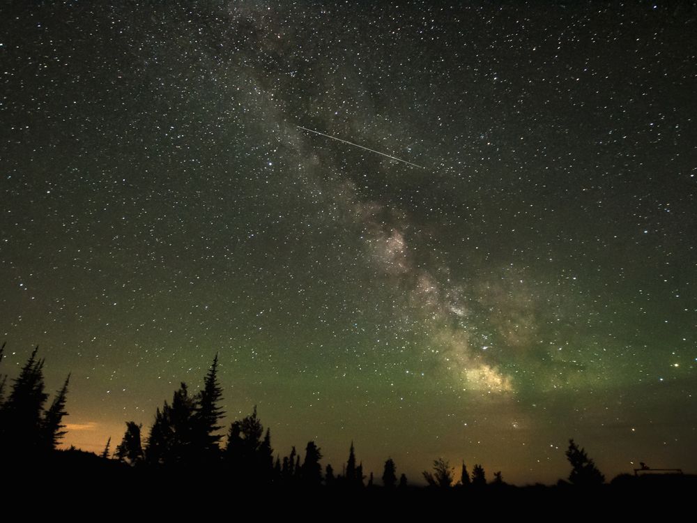 A shooting star streaks across a star-filled sky in British Columbia