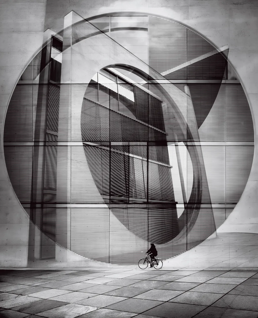 a person rides a bike next to a tall structure