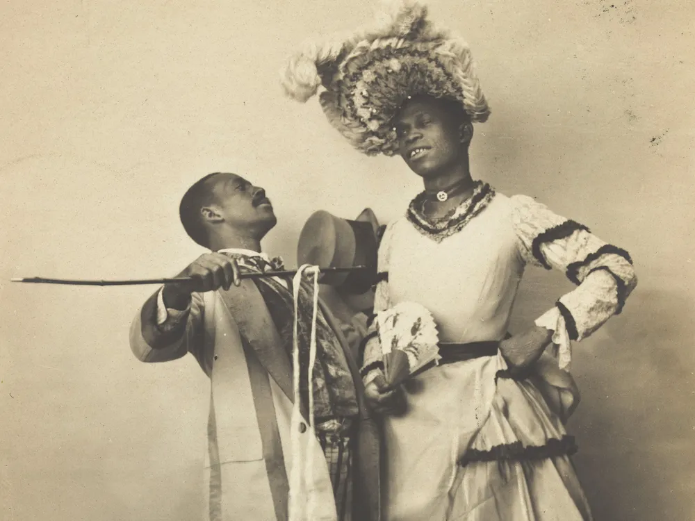 1903 postcard of two Black actors, one of whom is dressed in drag, performing a cakewalk in Paris