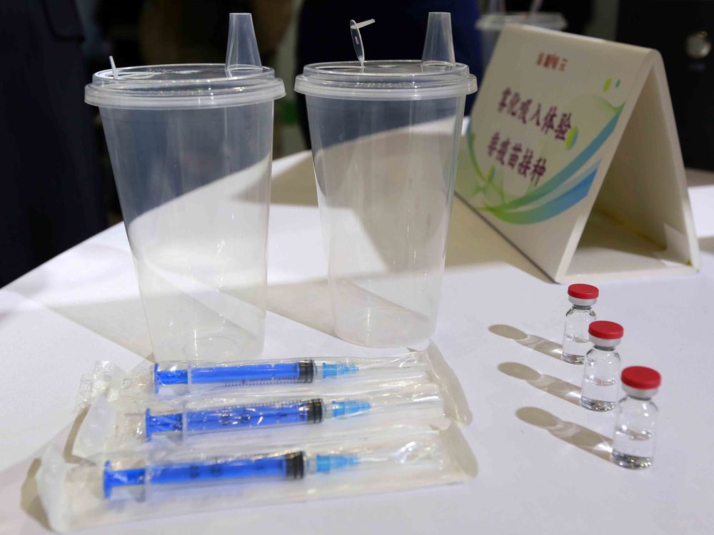 Vials, cups and syringes for a Covid-19 vaccine on a table.