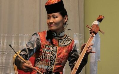 Ayana Mongush, a throat singer from Kyzyl in the Republic of Tuva, Russian Federation, plays an igil. She is part of Tyva Kyzy, an all-female throat singing group, a profession which was traditionally prohibited for women.