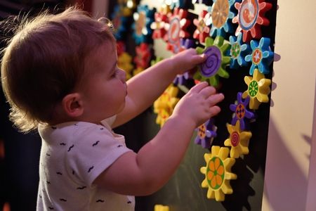 Young child experiences hands-on play experience with objects