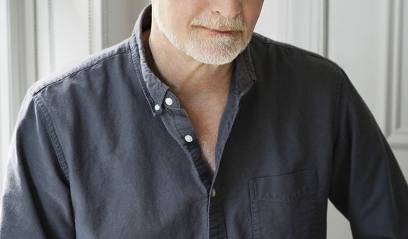 A portrait of a man wearing a dark shirt