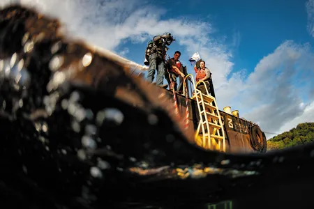 A diver prepares to enter the water of Malakal Harbor in Palau, where the plane flown by U.S. Navy pilot Jay Ross Manown Jr. was shot down in September 1944.