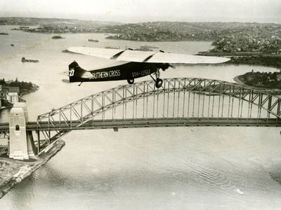After his celebrated trans-Pacific flight, Charles Kingsford Smith flies the famed Southern Cross over Sydney Harbor.