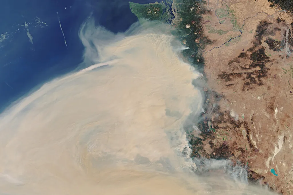 A satellite image shows wildfire smoke over the west coast of the United States