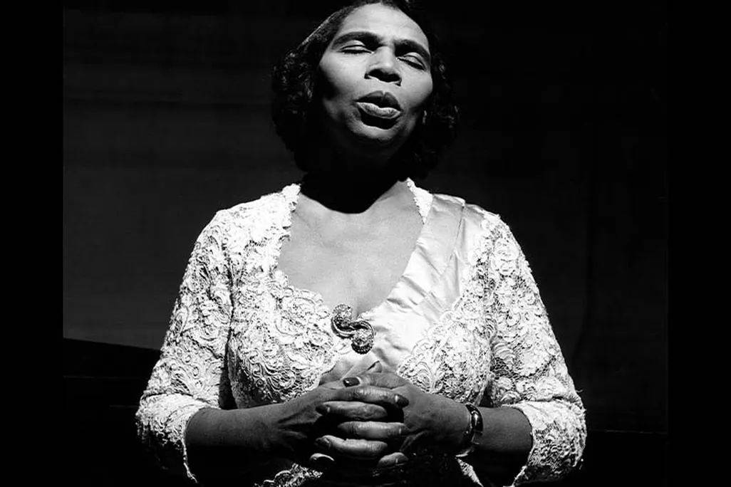 A women sings wearing a white dress