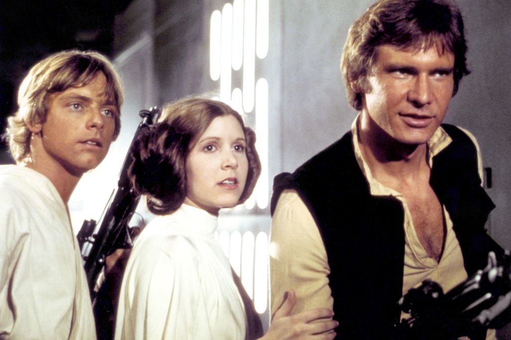 A man in a white tunic, a woman in a white dress and a man in a black vest