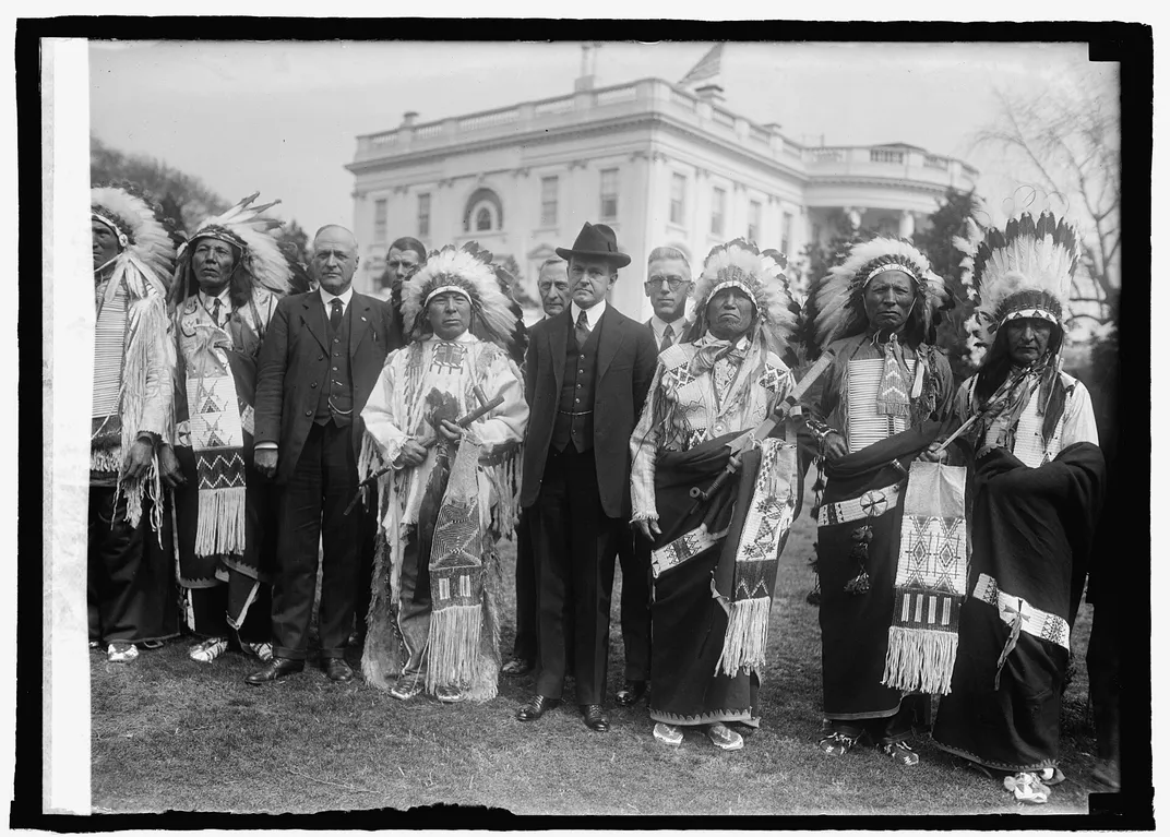 Coolidge poses next to Sioux representatives on the White House lawn in 1925.