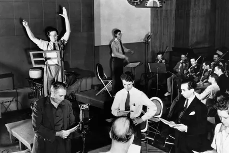 Orson Welles (arms raised) rehearses his radio depiction of H.G. Wells' classic, The War of the Worlds. The broadcast, which aired on October 30, 1938, and claimed that aliens from Mars had invaded New Jersey, terrified thousands of Americans.