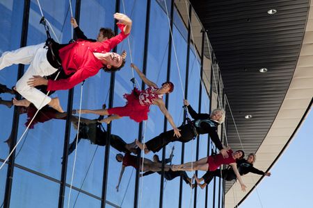 Sir Richard Branson (c) along with son Sam (left in black) and daughter Holly (far right) performing with Project Bandaloop on the side window wall of the Virgin Galactic Gateway to Space Hangar, Monday October 17, 2011 near Las Cruces, New Mexico.
It was part of a dedication and christening of the hangar to Virgin Galactic.