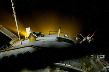 Space station astronauts photographed the glowing thrusters of a Progress spacecraft during a 14-minute firing that raised the space station's orbit by almost two miles.