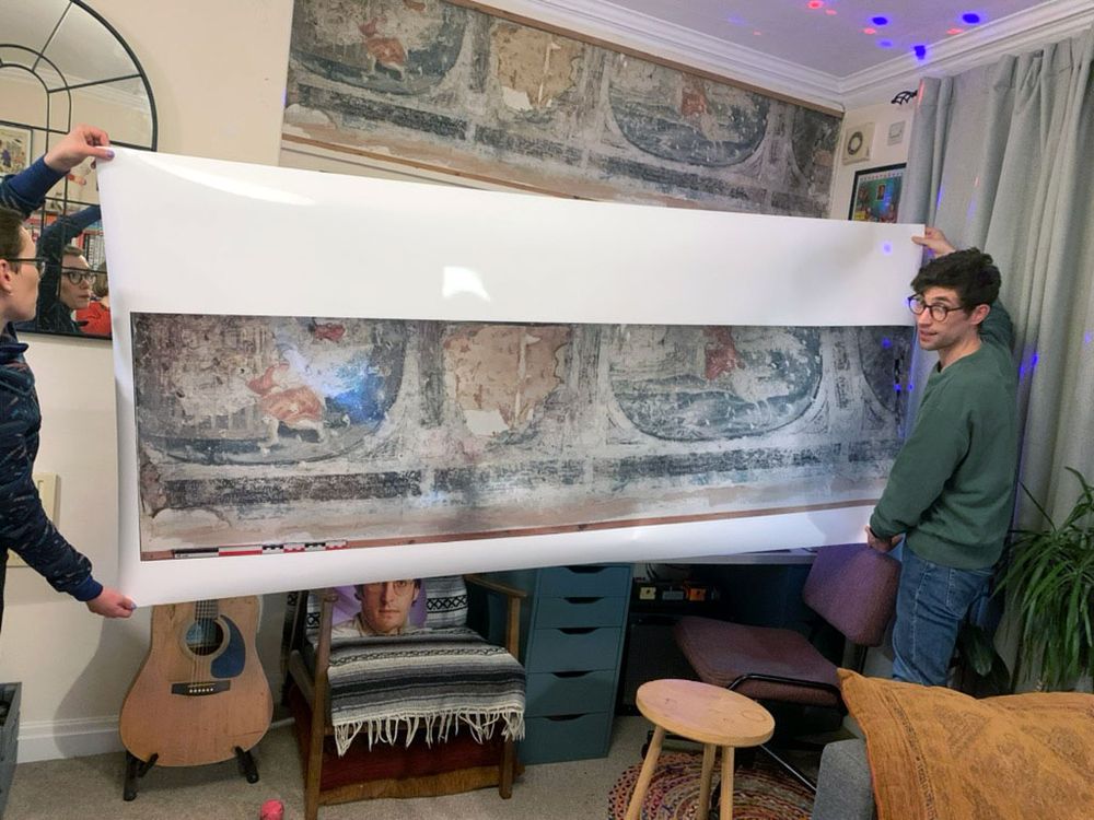 Luke Budworth holds replica of mural