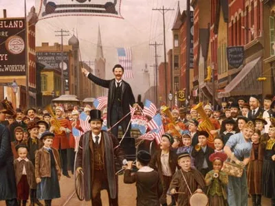 Parade with banner showing head and shoulder portraits of Grover Cleveland, Adlai E. Stevenson and Gov. John Peter Altgeld.
