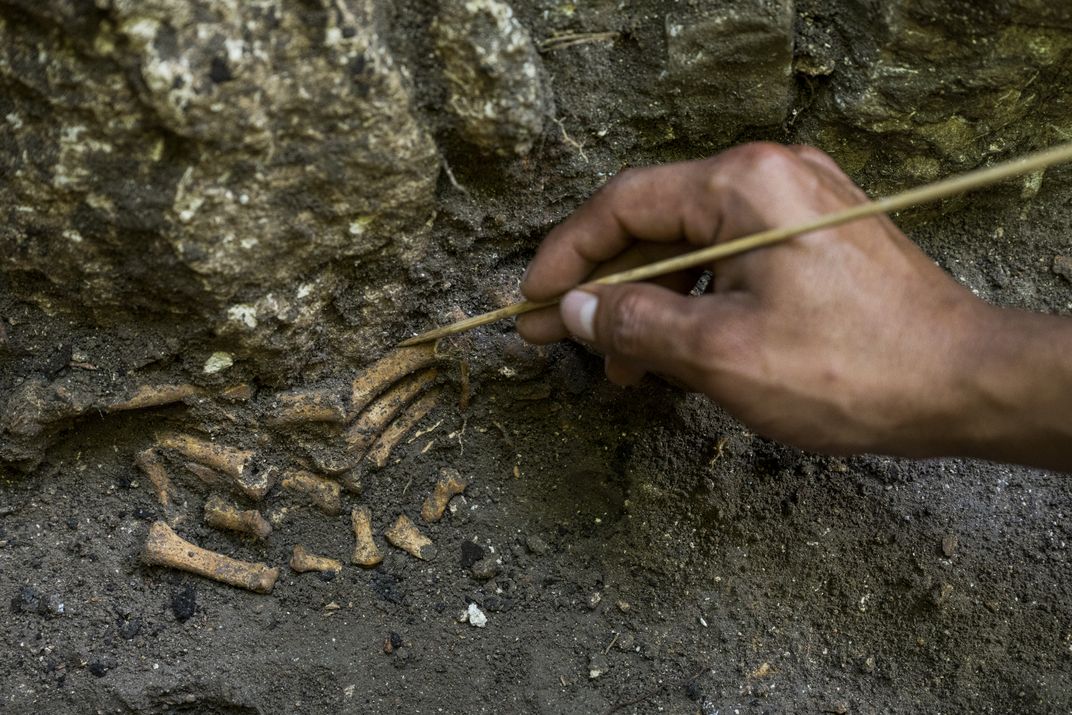 A team member carefully unearths toe bones in what was once a residential area.