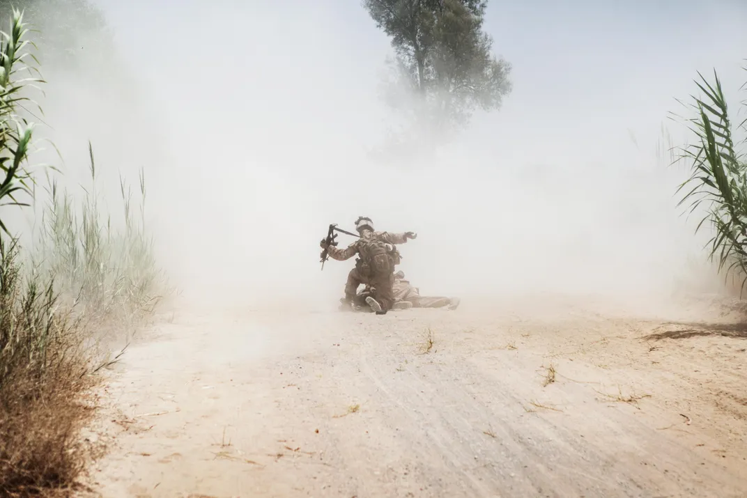 Cpl. Eric Hopp helps Cpl. Manuel Jimenez