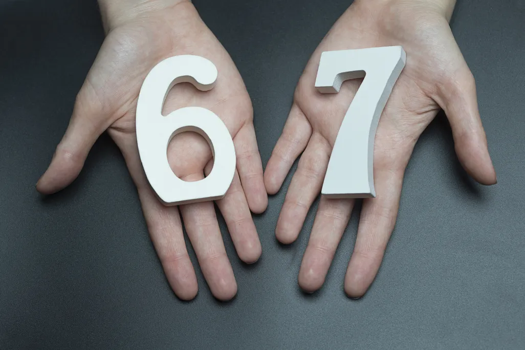 Two hands holding the numbers six and seven