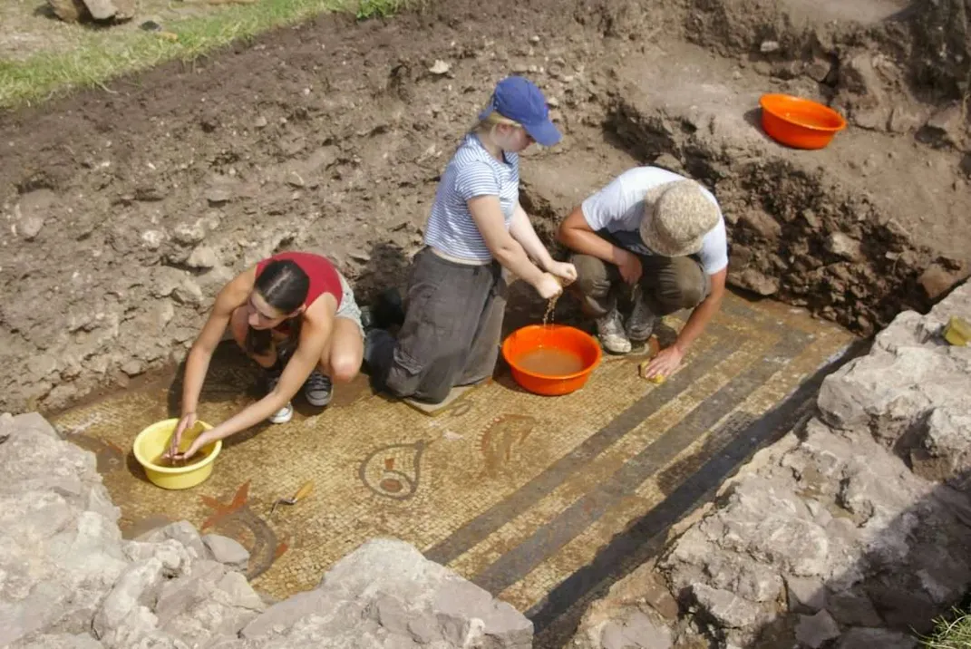 Archaeologists washing a mosaic